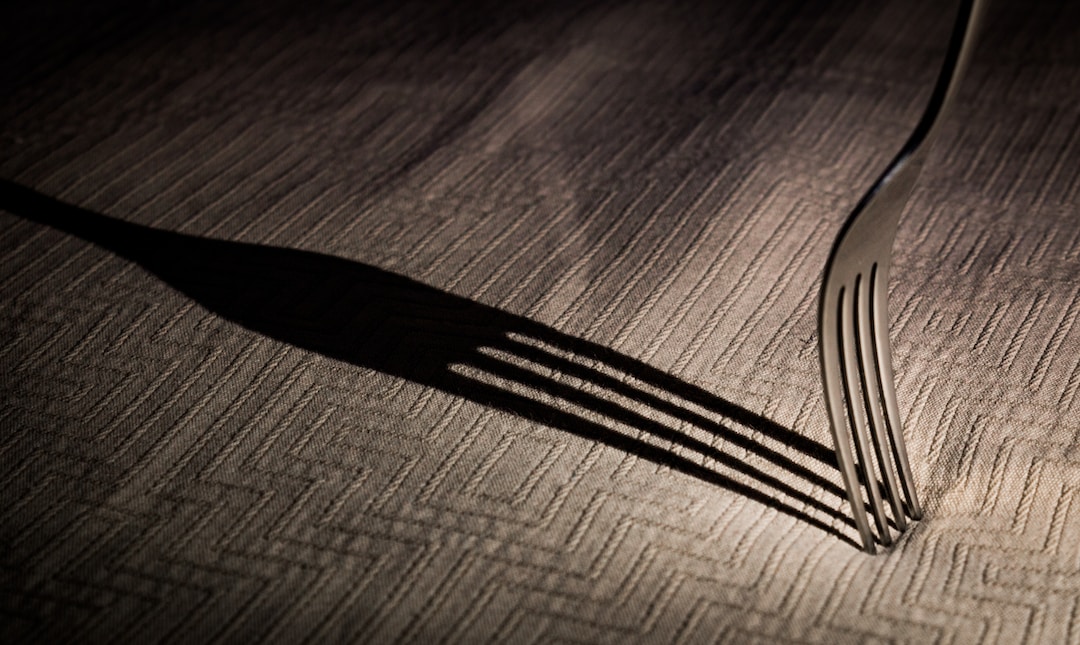 stainless steel fork on brown wooden table